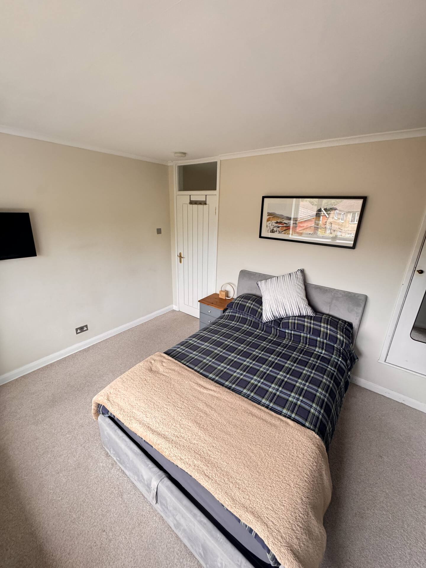 An overview of the double bed, TV and bedroom